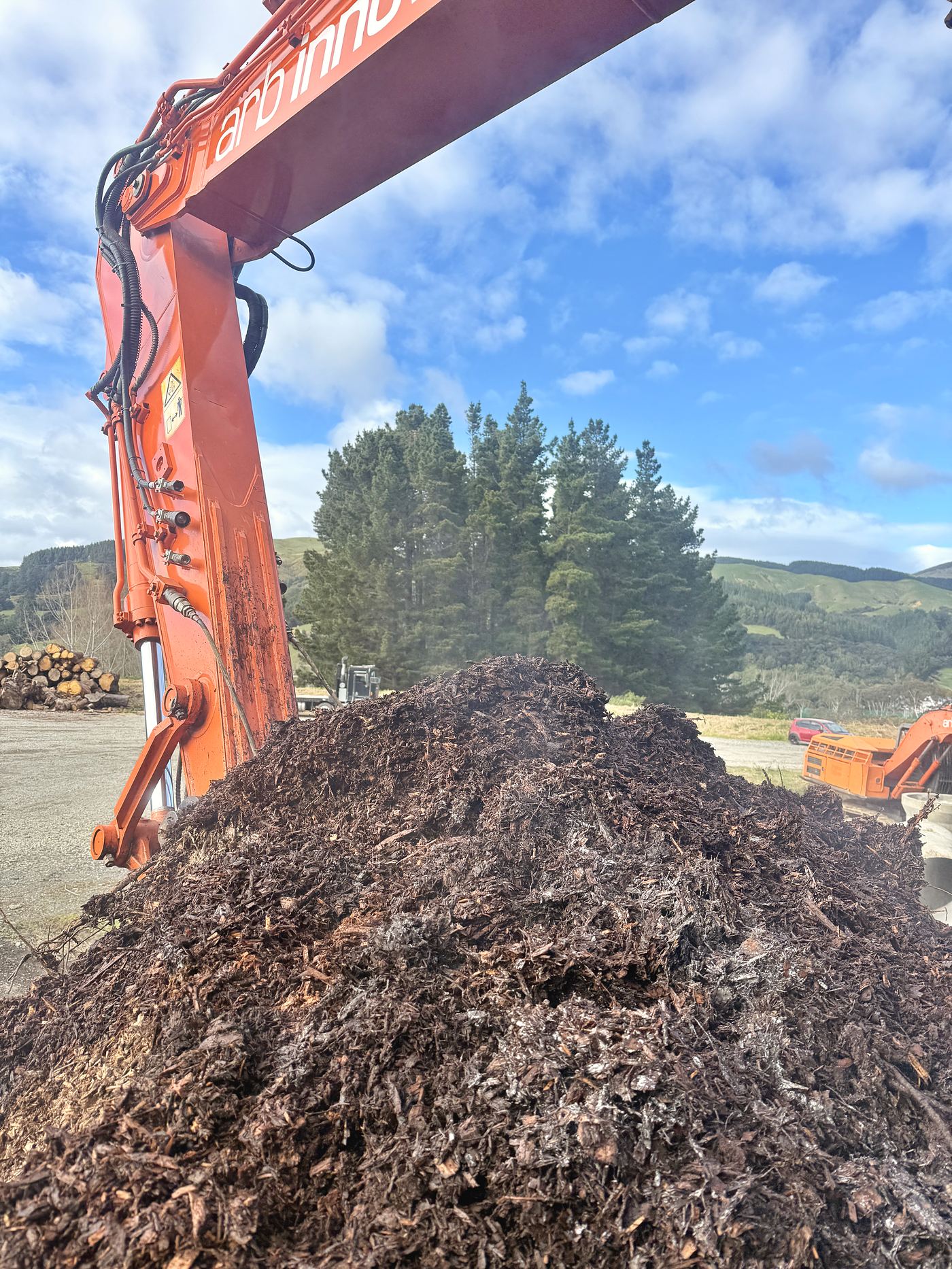 An Arb Innovations excavator working a stockpile of aged mulch at the depot